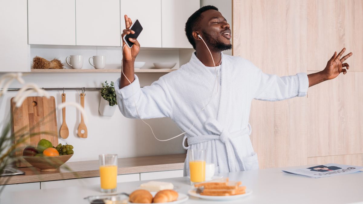 happy man in the kitchen listening to music