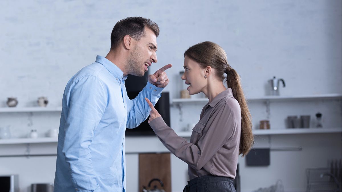 couple fighting in living room pointing at each other