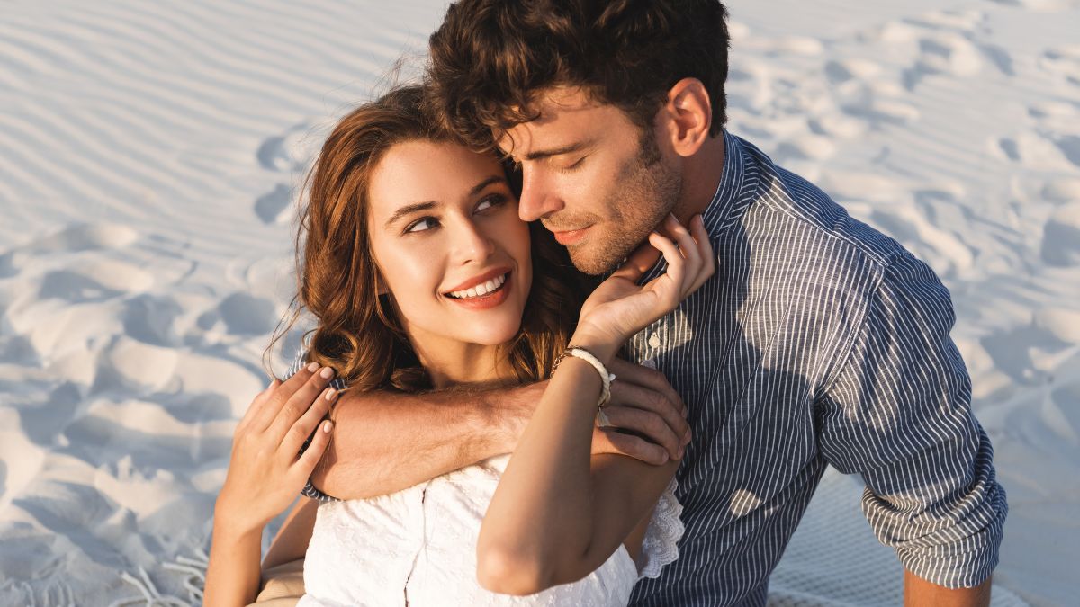 couple hugging while on white sand