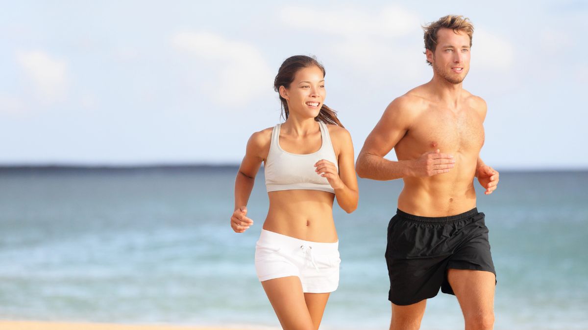 couple running on the beach by the ocean