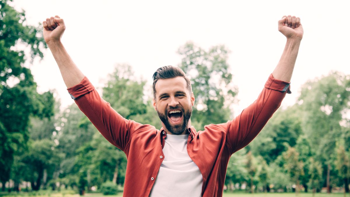 excited man outside with his hands up