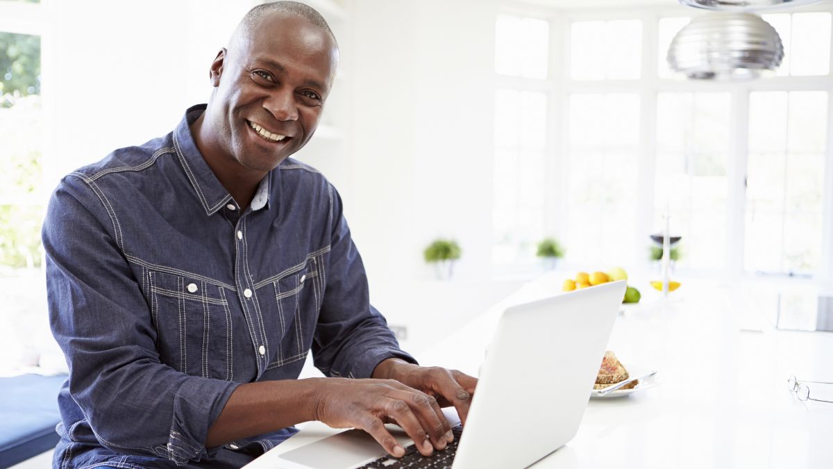 middle aged man working at computer in kitchen