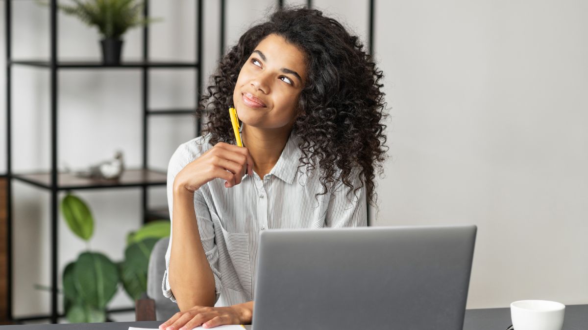 woman at home office thinking and smiling