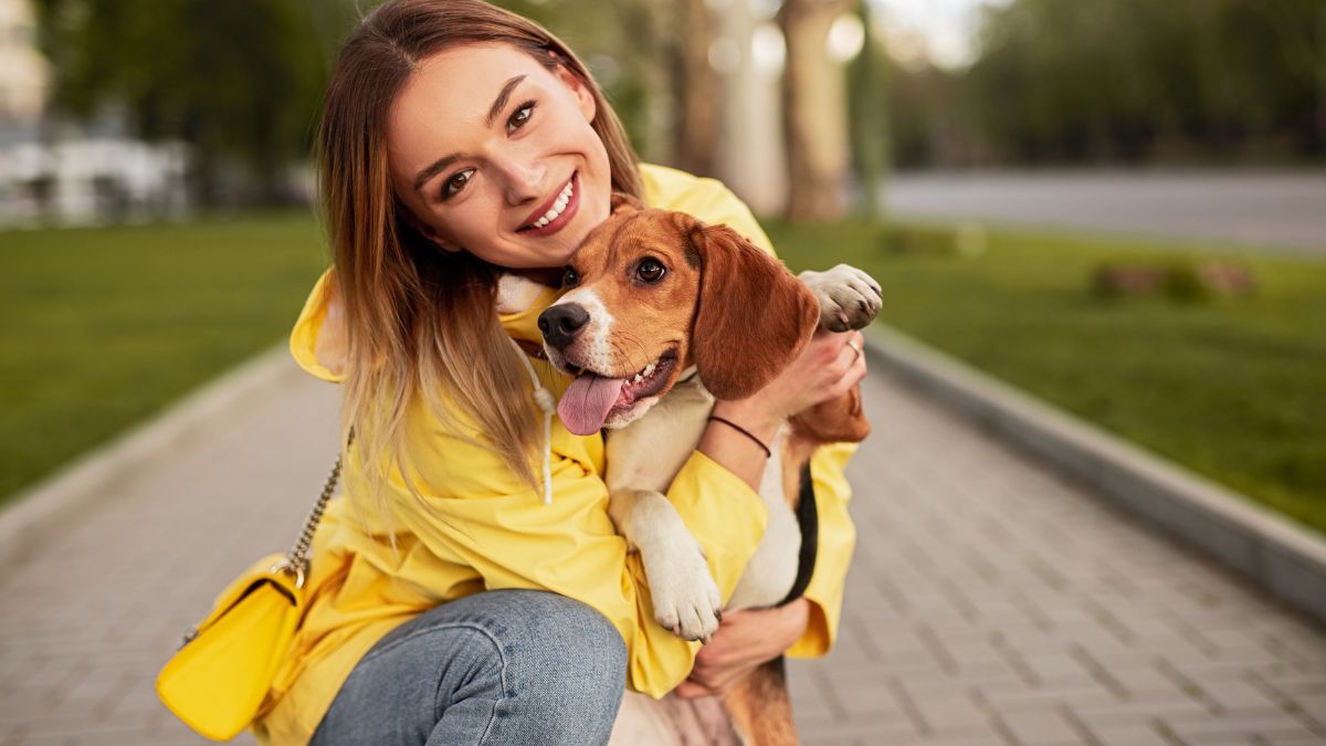 woman hugging her dog on the sidewalk