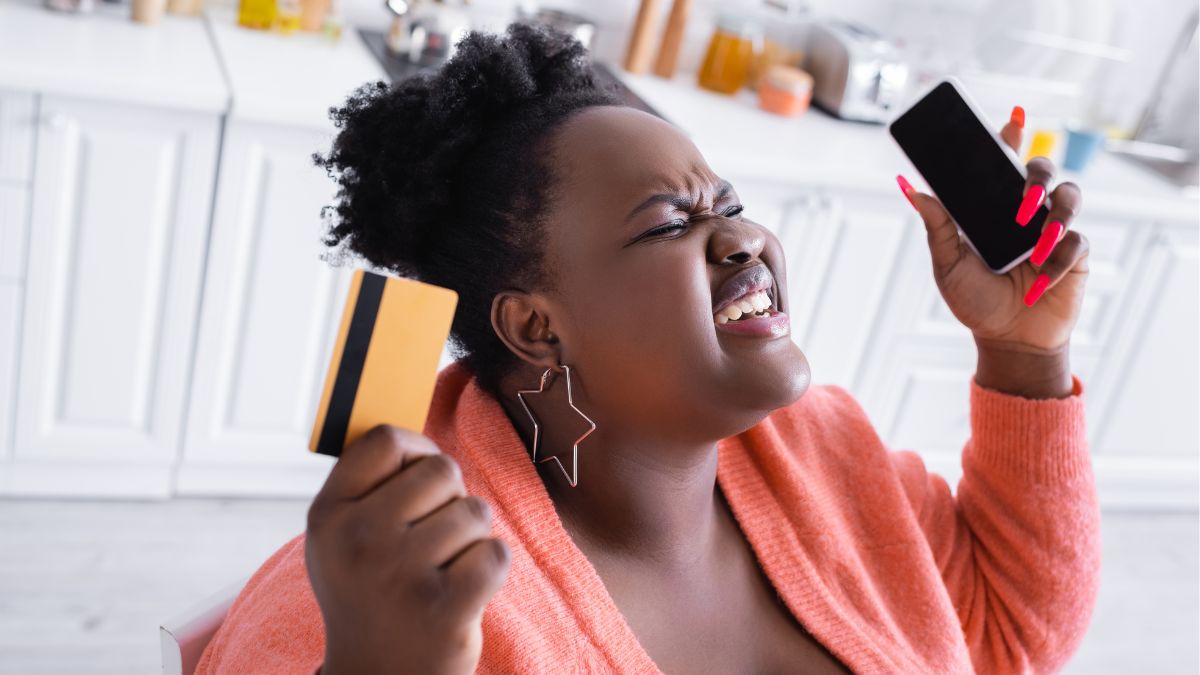 woman looking stressed with credit card and phone