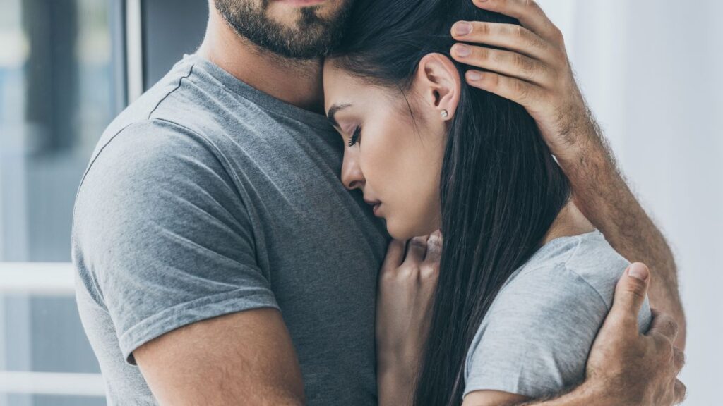 woman's head on a mans chest hugging 