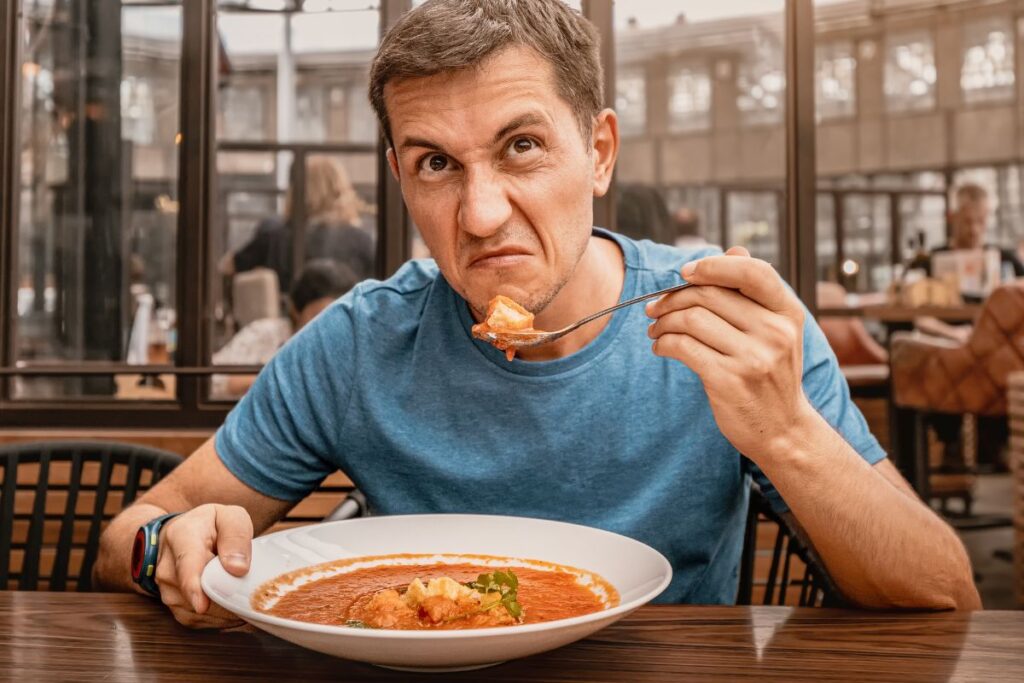 Man unhappy eating food at a restaurant